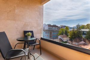 a balcony with a table and chairs and a large window at Harizma apartmani - Maja in Kragujevac +15 photos