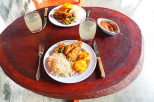 two plates of food on a wooden table at Somoto Canyon Hostal in Los Potrerillos
