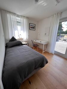a bedroom with a bed and a desk and a window at Tor ins Allgäu in Füramoos