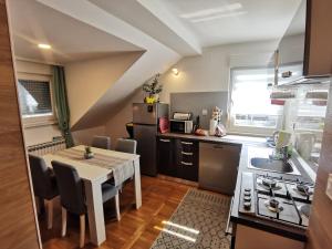 a kitchen with a table and a small kitchen with a stove at Apartmani Jastreb 2 in Jastrebarsko