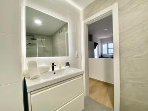 ein weißes Badezimmer mit Waschbecken und Spiegel in der Unterkunft Balcón de la Paz in Antequera + 36 Fotos