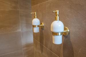 two white and gold wall lights in a bathroom at Wellnesshuisje Bunga Baco in Lanaken
