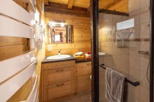 a bathroom with a sink and a shower in a log cabin at Les Chalets du Bonheur in Les Houches +57 photos