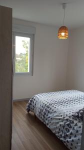 una camera da letto bianca con un letto e una finestra di Petite maison avec jardin a Landrévarzec Altre 6 foto