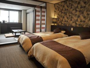 a hotel room with three beds and a table at Hotel Kanronomori in Niseko