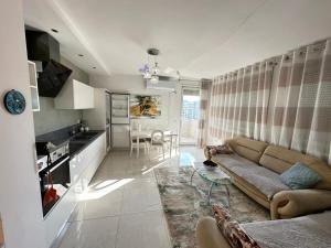 ティラナにあるAlma Guestのソファとキッチンのあるリビングルーム