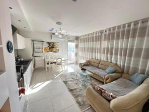 ティラナにあるAlma Guestのソファとテーブルのあるリビングルーム