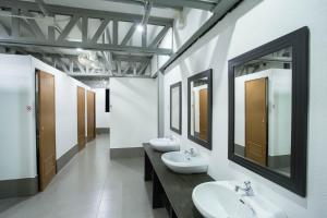 a bathroom with three sinks and two mirrors at A Plus Hotel in Ko Lipe