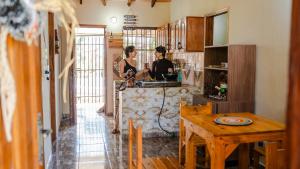 two women in a kitchen with a table at La Casita de Aregua in Itauguá
