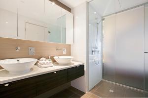 a bathroom with a sink and a glass shower at Darwin Waterfront Luxury Suites in Darwin +138 photos