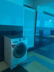 a washing machine in a room with a blue light at Hayes Court Luxury Apartments in Meetotamulla