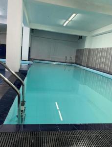 a large swimming pool with blue water in a building at Hayes Court Luxury Apartments in Meetotamulla
