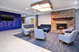a lobby with a couch and chairs and a fireplace at Holiday Inn Express & Suites Milwaukee NW - Park Place by IHG in Milwaukee