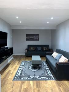 a living room with a couch and a coffee table at Everything You Need I Super Comfy I Sleeps 7 I WiFi I Parking I 4BDR in Dagenham