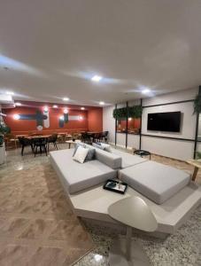 a living room with a white couch and a table at Apartamento completo e moderno com ar condicionado e piscina no centro do RIO in Rio de Janeiro