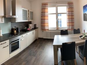 a kitchen with a table and a dining room at Ferienwohnung CITY - direkt am Falderndelft - nähe Innenstadt in Emden