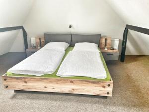 a bedroom with a wooden bed with two white pillows at Ferienwohnung CITY - direkt am Falderndelft - nähe Innenstadt in Emden