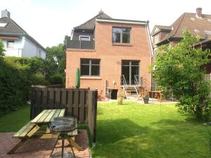 a backyard with a picnic table and a house at Ferienwohnung CITY - direkt am Falderndelft - nähe Innenstadt in Emden