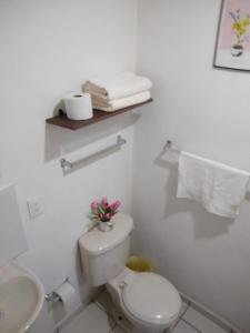 a white bathroom with a toilet and a sink at Casa Okadiz in Rancho de la Cruz