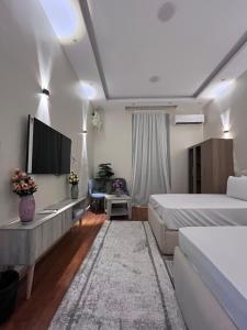 a hotel room with two beds and a flat screen tv at New Downtown studios in cairo in Cairo