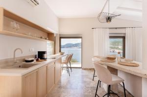 a kitchen with a counter and chairs and a large window at Blanche Cliff Apartments in Sveti Stefan