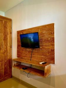 a flat screen tv on a wooden wall at Uma Sindu Homestay in Sanur