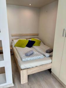 a small bed in a room with green pillows on it at Ava Central Residence in Budapest