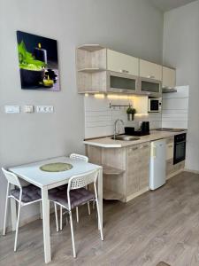 a kitchen with a table and a white table and chairs at Ava Central Residence in Budapest +7 photos