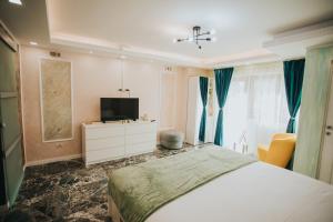 a bedroom with a bed and a flat screen tv at Alessandra Studio 2 in Piatra Neamţ