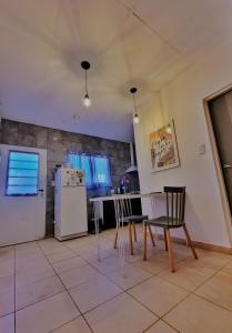 a kitchen with a table and chairs and a refrigerator at Güemes 4 in General Roca