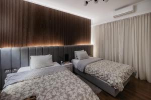 a bedroom with two beds and a wall with curtains at The Palm Terrace Penthouse 3BR - Palm Hills - 280 sqm in Cairo