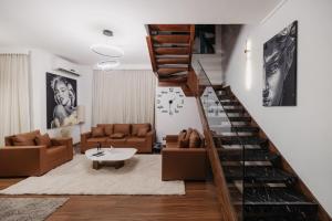 a living room with a staircase with a couch and a table at The Palm Terrace Penthouse 3BR - Palm Hills - 280 sqm in Cairo