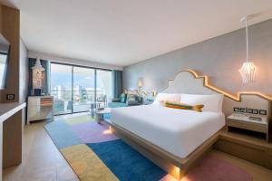 a bedroom with a large white bed and a living room at W Algarve in Albufeira