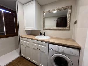Un baño con lavabo y lavadora. en Biescas Suites, en Biescas