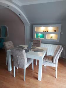 a white table with chairs and a laptop on it at Stan na dan PREMIUM 2 apartman in Obrenovac +12 photos