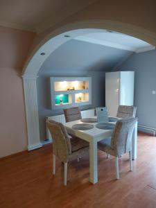 a dining room with a white table and chairs at Stan na dan PREMIUM 2 apartman in Obrenovac