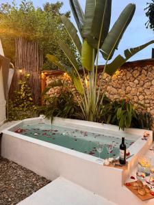 un jacuzzi dans un jardin avec une table et des verres à vin dans l'établissement Casa de playa Kommox Beach, à Carthagène des Indes