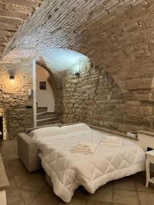 a bedroom with a large bed in a stone wall at La Grottina in Perugia