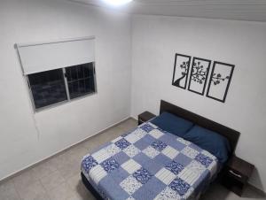 a bedroom with a blue and white bed and a window at La Esmeralda, Rocha in La Esmeralda