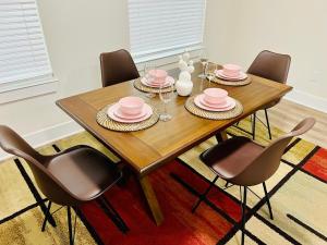 a dining room table with pink dishes and chairs at Apt 2 Bedrooms 2 Full Baths FREE Parking & FREE Laundry in Unit in The Woodlands +36 photos