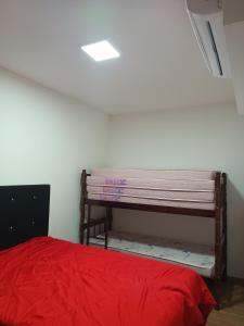 ein Schlafzimmer mit einem Bett mit einer roten Decke in der Unterkunft Apartamento Frente Mar in Barra Velha