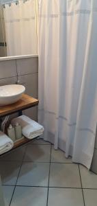 a bathroom with a sink and a shower curtain at Aguaribay Deptos Mendoza in Guaymallen +14 photos