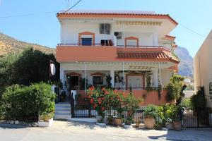 a large house with flowers in front of it at Xenos Apartments in Keratokampos