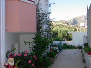 a garden with pink flowers on a building at Xenos Apartments in Keratokampos +25 photos