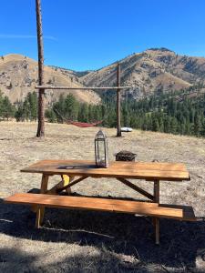 a picnic table with a lantern on it in a field at Tent 2 Oxen-Le-Fields Montana in Conner