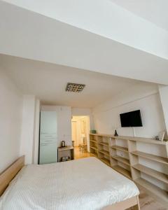 a white room with a bed and a flat screen tv at Calvin Apartment 10 in Ohrid