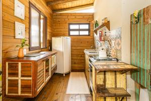 a kitchen with a white refrigerator and wooden walls at Casa do Cumbata in Guarda do Embaú