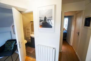 un corridoio con porta che conduce a una camera con bagno di Appartement 2 pièces "Le Cocon Urbain" - Rénové et Cosy - Proche Paris & Disneyland a Neuilly-Plaisance