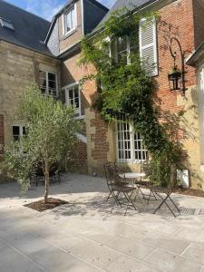 a building with a table and chairs in front of it at L'Écrin du Marquis 