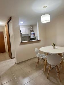 a dining room with a table and chairs and a kitchen at Departamento Premium, Paseo Buen Pastor in Cordoba +8 photos